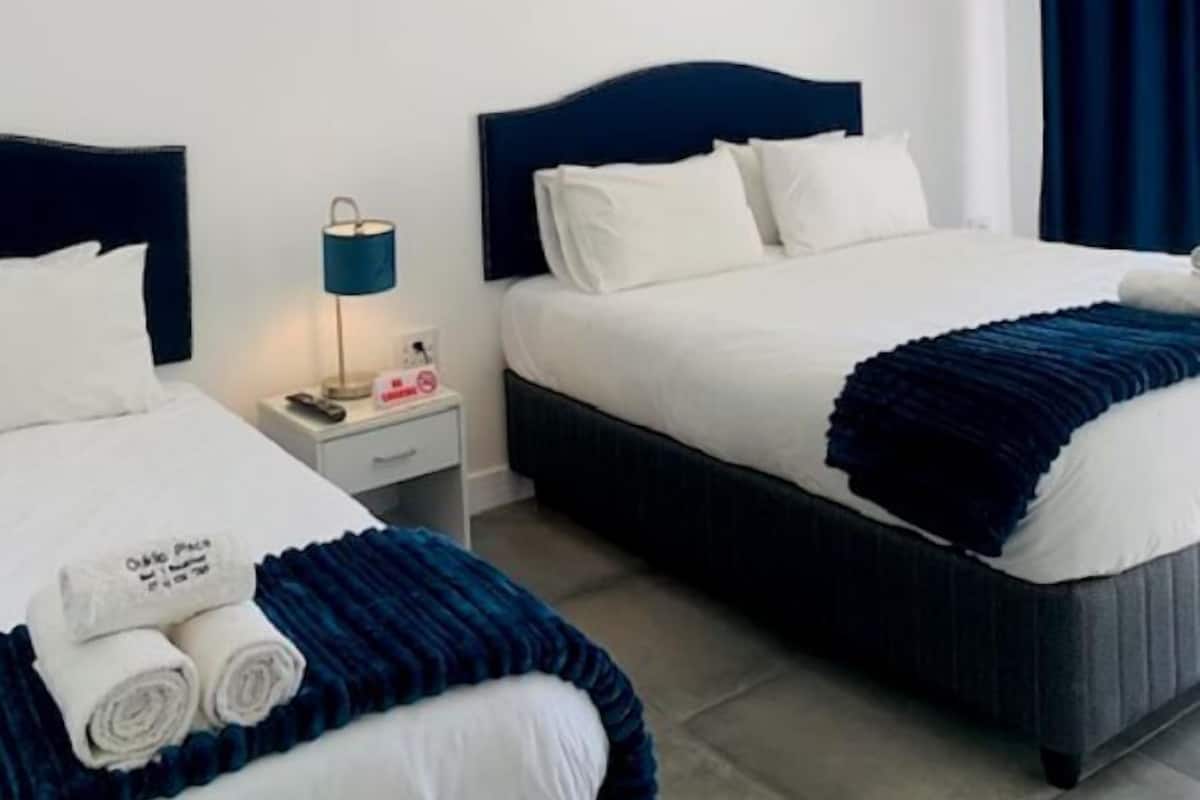 1 habitación, escritorio, tabla de planchar con plancha y ropa de cama