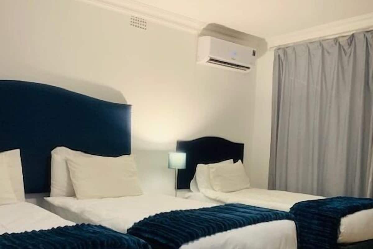 1 habitación, escritorio, tabla de planchar con plancha y ropa de cama