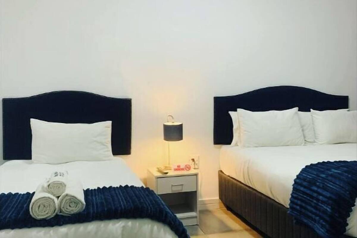 1 habitación, escritorio, tabla de planchar con plancha y ropa de cama