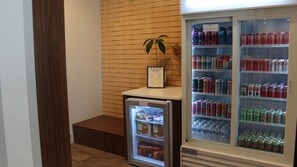 Ein Hotelzimmer mit Minibar, einem kleinen Kühlschrank mit Snacks und einem größeren Kühlschrank mit Getränken.