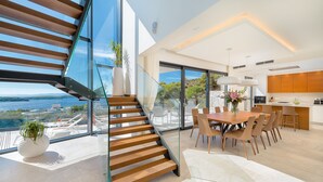 A modern interior with a staircase leading to a balcony overlooking a scenic view. - Luxury Villa Princess of Hvar with Pool (Hvar)