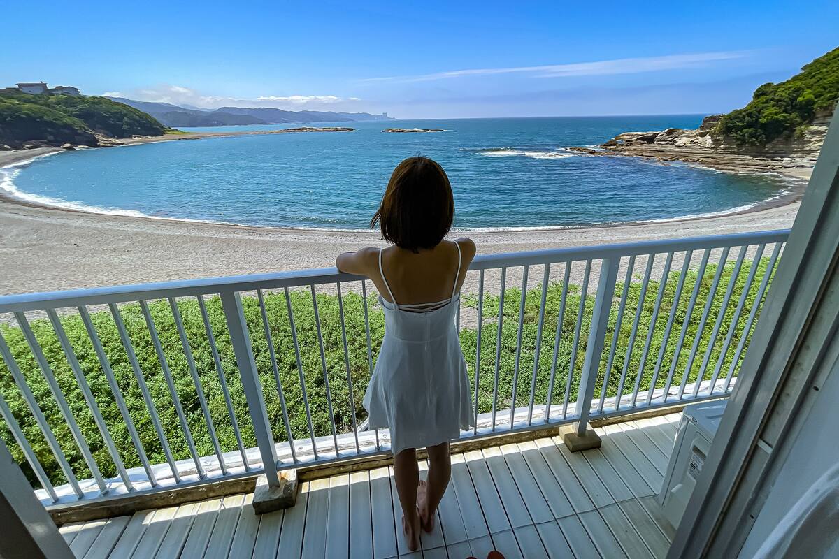 A balcony with a view of a beach and ocean.