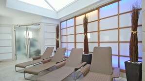 Un espacio interior moderno para relajarse, con sillones, una puerta de cristal y una pared con diseño de cuadrícula.