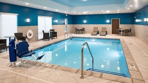 A swimming pool with a blue and white tiled floor, a pool ladder, and a lifeguard chair. - Hampton Inn Hastings (Hastings)