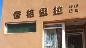 A building with a stone facade and a sign in a foreign language. - Shangrila (Dongyin Town)