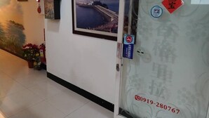 A corridor with a framed picture of a bridge, a door with a phone number, and a no-smoking sign. - Shangrila (Dongyin Town)