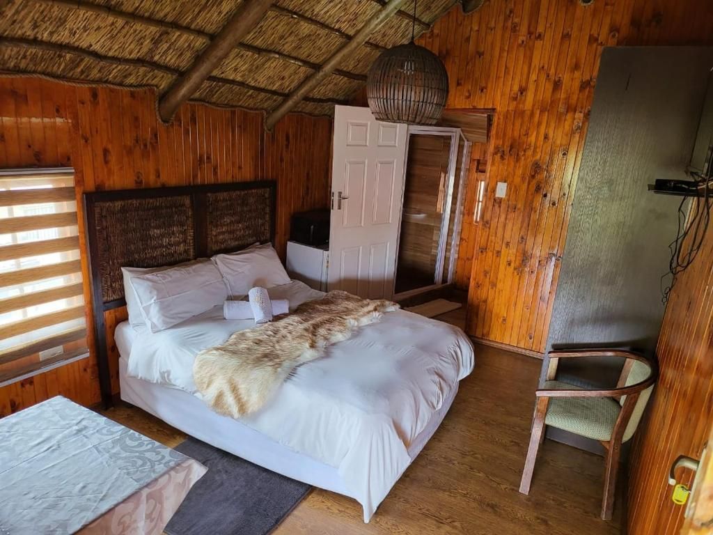 Ein Zimmer mit Holzboden, einem Bett, einem Sessel und einem Kleiderschrank.