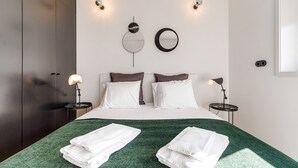A modern bedroom with a large bed, two bedside tables, and a green throw blanket. - Nomad's Family - 2BDR Spacious Apartment Gaia (Vila Nova de Gaia)