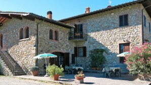 A stone building with a staircase, outdoor seating area, and potted plants. - Beautiful apartment in villa for 7 people with pool, WIFI, TV, terrace and pets allowed (La Casetta)