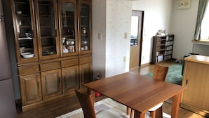 A compact kitchen with wooden cabinets and a dining table.