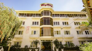 Een hotel met een opvallend bord waarop "Bing Bong" staat en een balkon op de tweede verdieping.