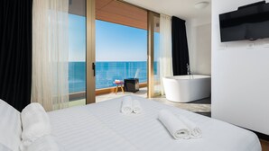 Una habitación de hotel con una cama grande, una bañera y un televisor.
