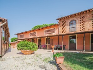 Experience the charm of a traditional Mediterranean-style building with a covered patio and lush garden.