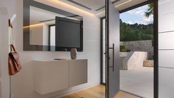Un intérieur moderne agrémenté d’un grand miroir, d’un téléviseur à écran plat et d’un design minimaliste.