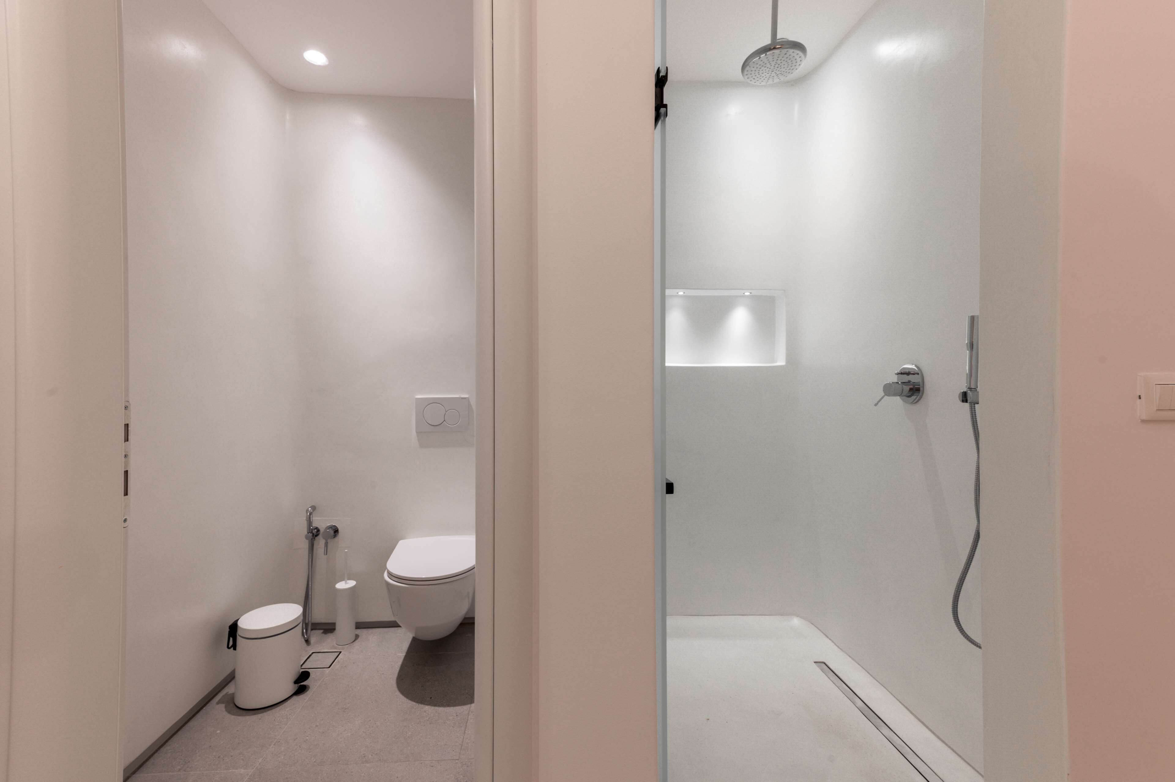Un baño moderno con inodoro, bidé y cabina de ducha a ras de suelo.