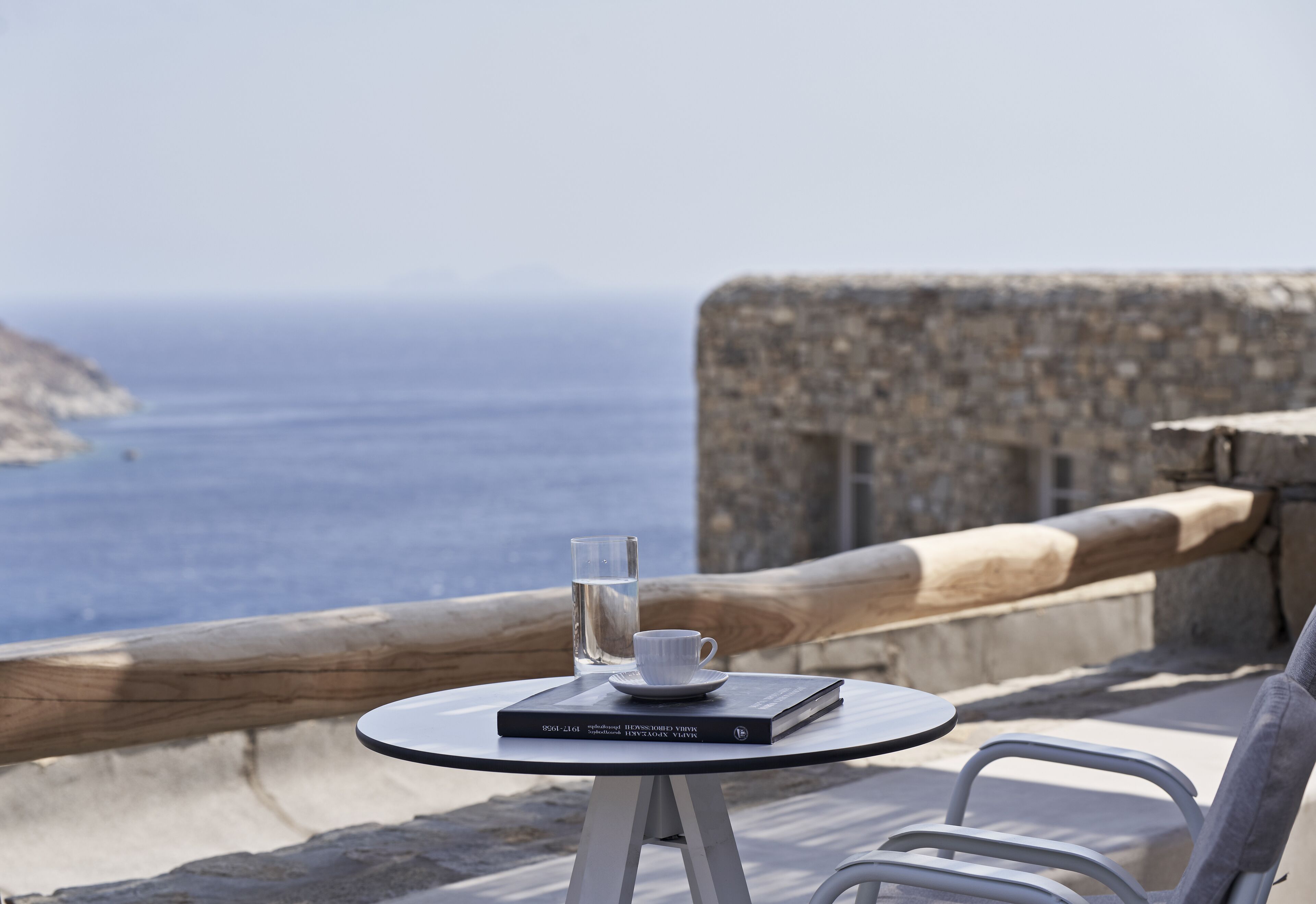 A table with a book and a glass of water, overlooking the sea.