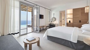 A modern hotel room with a large bed, a desk, and a view of the ocean. - Radisson Blu Euphoria Resort, Mykonos (Mykonos)