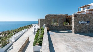 A stone building with a sign reading "Radisson Blu" and a view of the sea. - Radisson Blu Euphoria Resort, Mykonos (Mykonos)