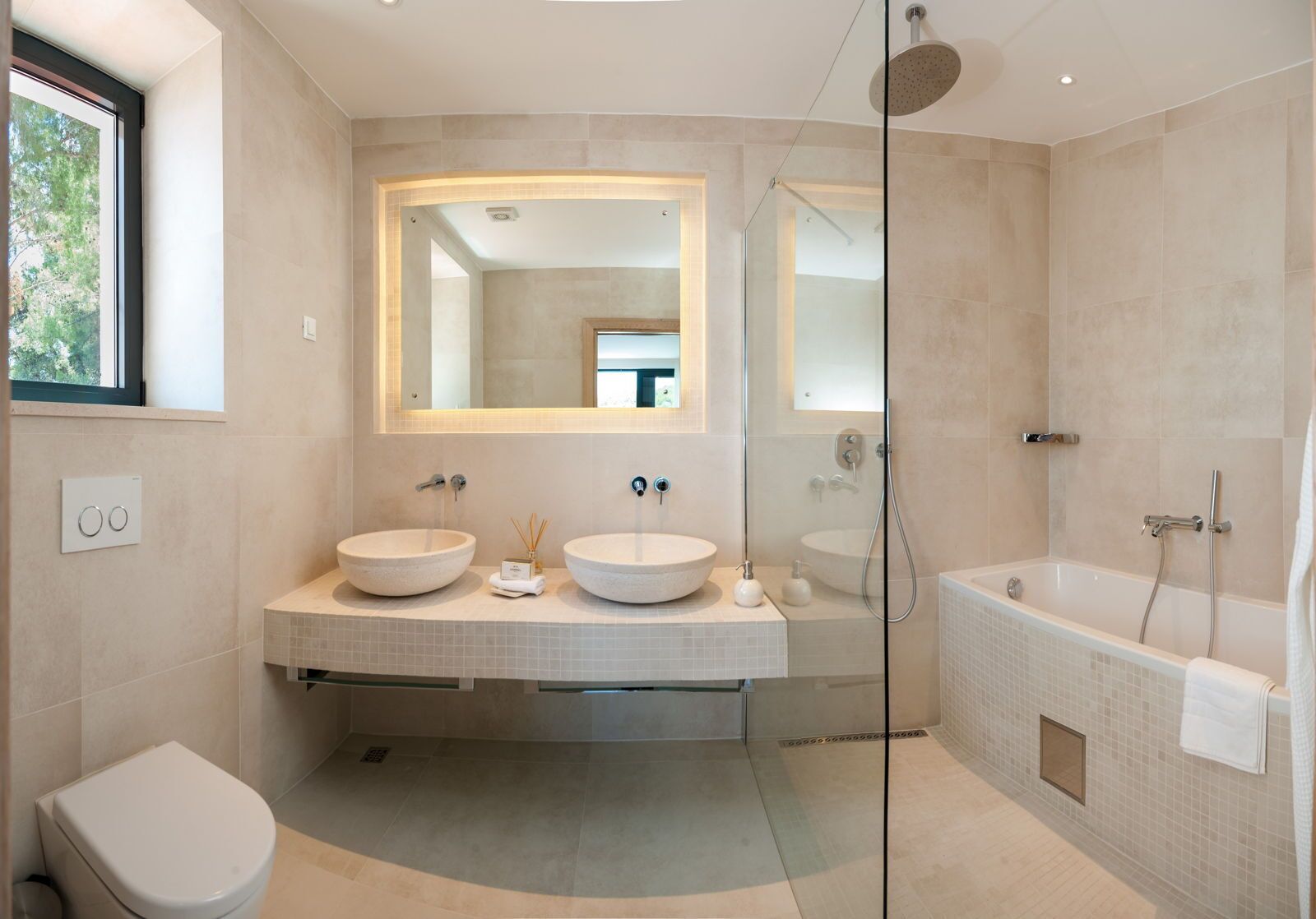 Ein modernes Badezimmer mit zwei großen, runden Waschbecken, einer gläsernen Dusche und einer separaten Badewanne.