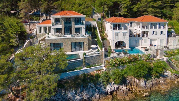 A coastal property with two large buildings, a swimming pool, and a rocky shoreline. - Luxury Villa Silent with Infinity Pool (Selca)