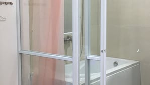 A glass-enclosed shower area with a shower curtain, a bathtub, and tiled walls. - Mai Tuan Pham Hung Hotel (Hoa Thanh)