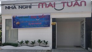 A building with a sign reading "MAI TUAN" and a banner advertising an event on 12/01/2020. - Mai Tuan Pham Hung Hotel (Hoa Thanh)