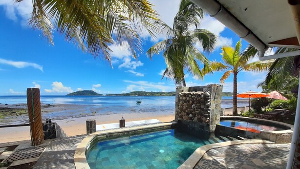 A pool area with a view of the beach and ocean. - Jazzybeach Hotel (Nosy Be)