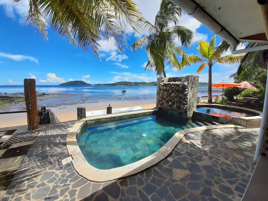 Una piscina al aire libre, sombrillas, sillones reclinables de piscina