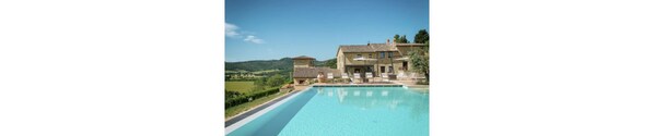 A large pool with a stone building in the background.