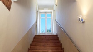 Eine hölzerne Treppe führt zu einer Tür mit einem Fenster darüber.