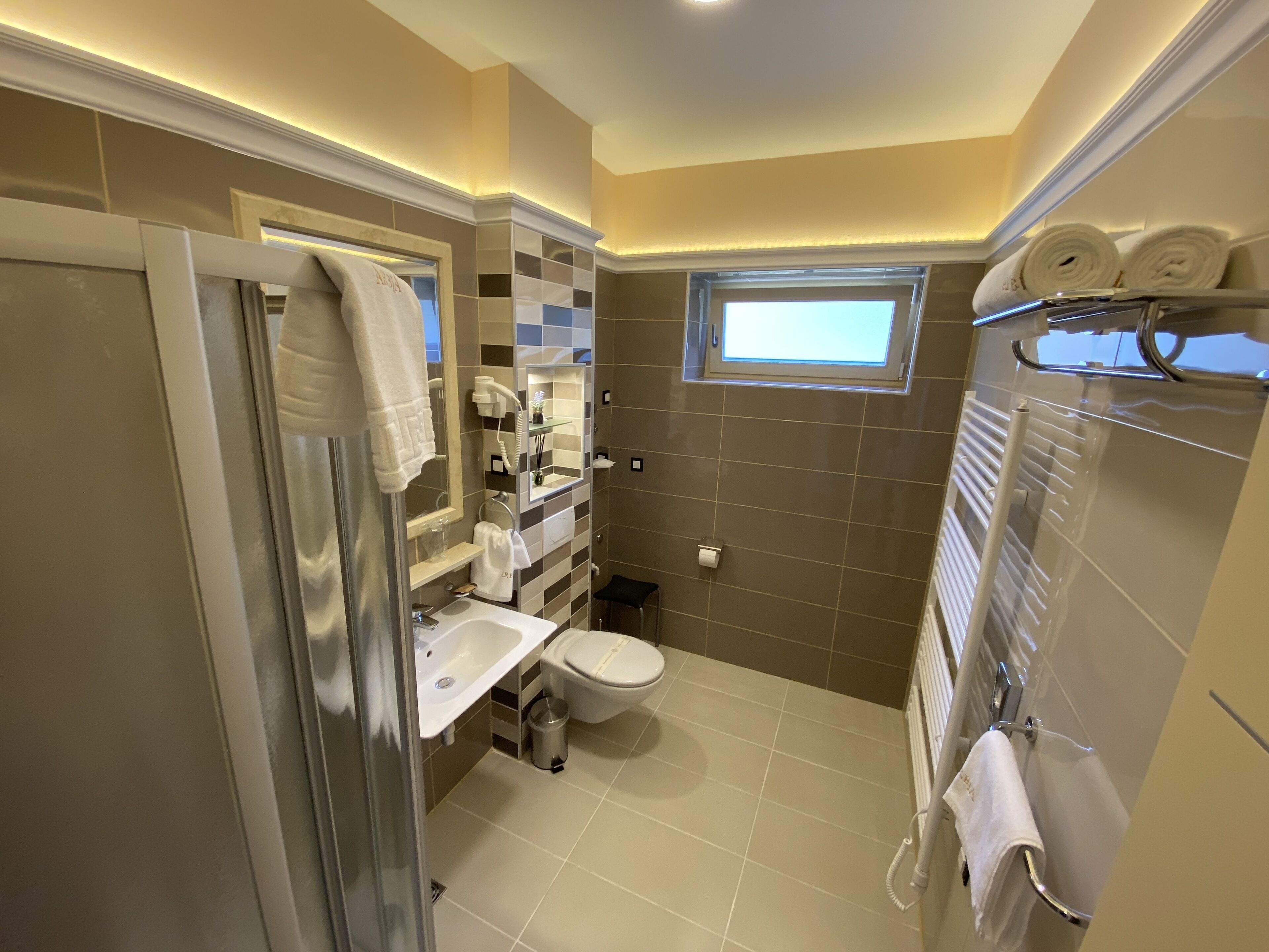 Een kleine badkamer met douche, toilet en wastafel.