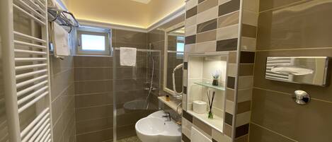 A modern bathroom with a glass-enclosed shower, a sink, and a toilet.