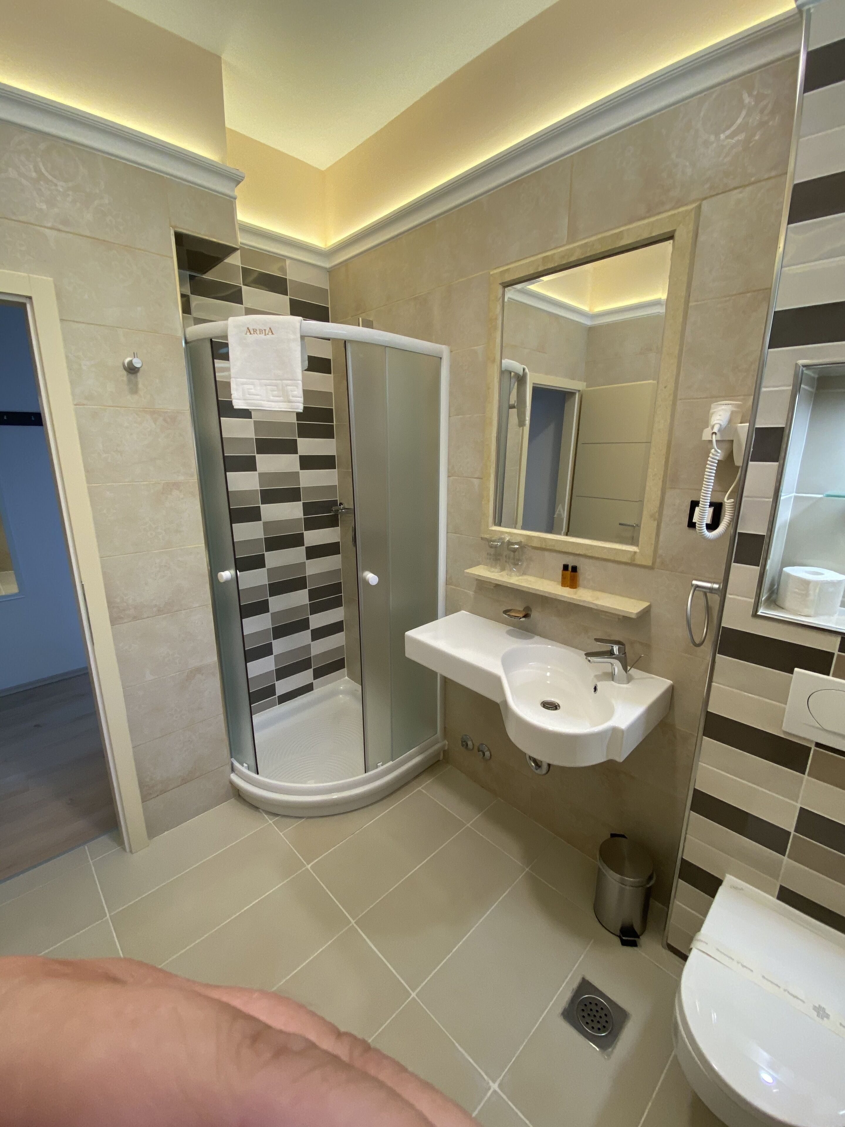 Une salle de bain moderne avec une douche à parois de verre, un lavabo et des toilettes.