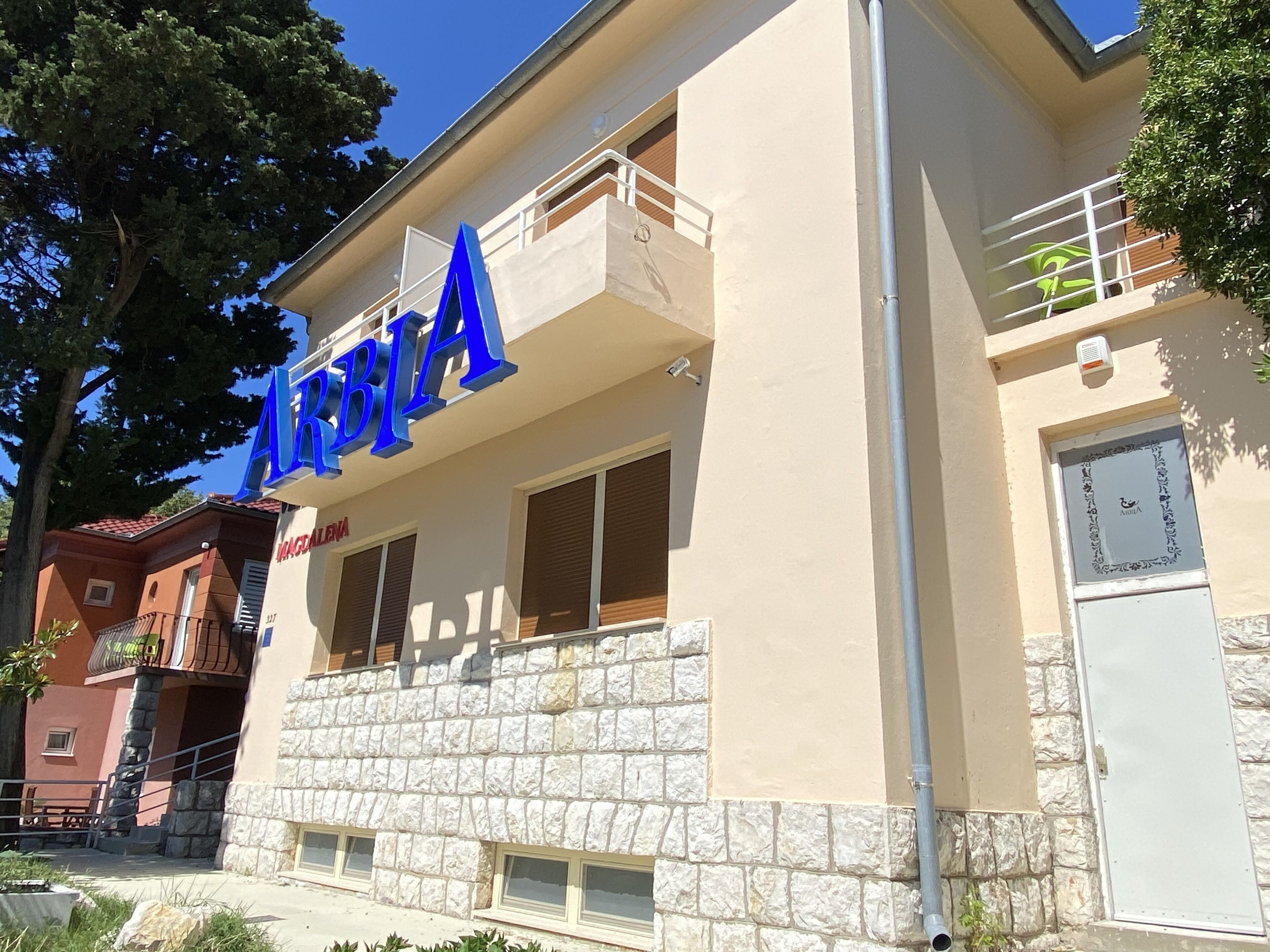 A building with a stone facade and a blue sign reading "ARQUITA".