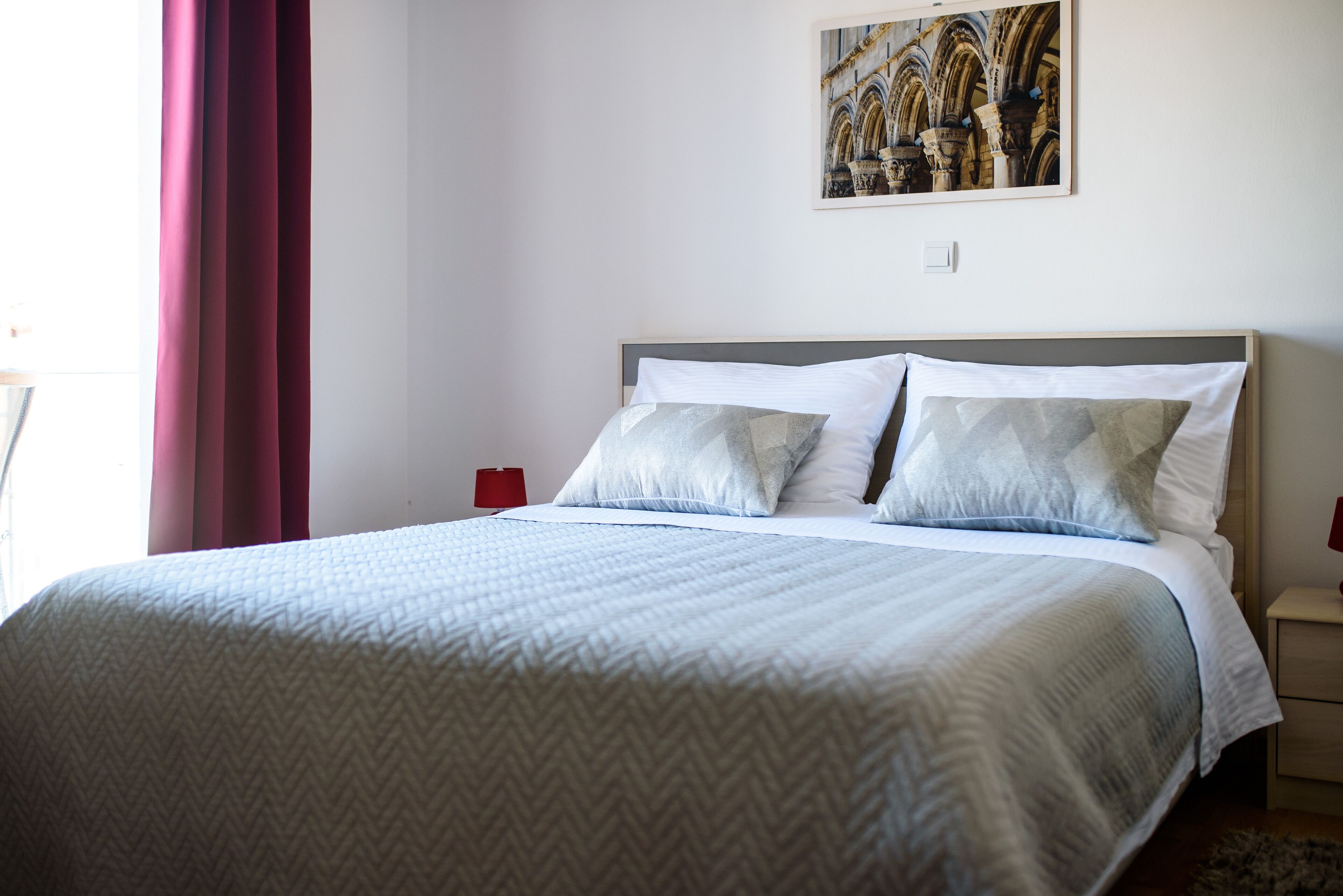 A neatly made bed with a patterned bedspread, two pillows, and a headboard.