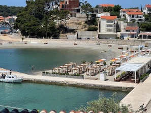 A coastal area with a marina, beach, and outdoor seating area with umbrellas. - Integrated Hotel Arbia - Margita Deluxe (Rab)