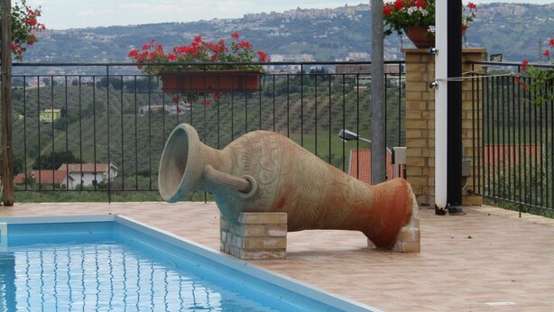A swimming pool with a large decorative cannon in the center.