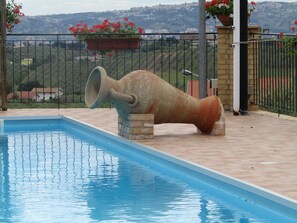 A swimming pool with a large decorative cannon in the center. - Hotel Opera (Moscufo)