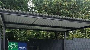 Un área de estacionamiento techada para bicicletas con un cartel que indica que forma parte de la red "E-Bike Ladestation".