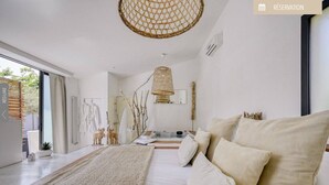 A modern bedroom with a large bed, a hanging light fixture, and a view of the outdoors. - Mas Sainte Marie - Private Hot Tub Suites (Saint-Laurent-d'Aigouze)