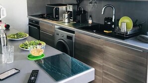 A modern kitchen with stainless steel appliances, a built-in oven, and a dishwasher.
