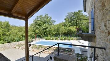 Relax by the serene pool surrounded by lush greenery and a variety of plants.