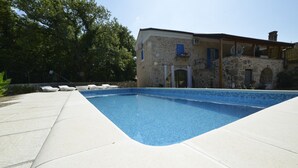 A swimming pool with a stone building in the background.