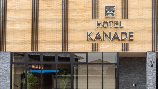 L’entrée d’un hôtel, avec une enseigne indiquant « HÔTEL KANADE ».