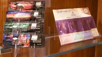 Exposició de productes per a la cura de la pell, incloent un netejador transparent, essència anti-envelliment, cera modeladora i loció hidratant post-afaitat.