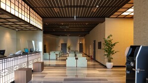 Un hall d’entrée spacieux comprenant un comptoir d’accueil, un espace salon et un distributeur automatique.
