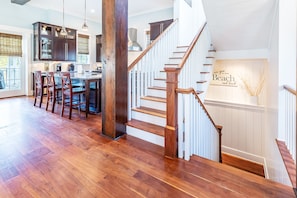 Staircase leads to an upper level with a kitchen area and seating.