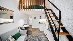 Un interior moderno con una escalera, un sofá, un comedor y una cocina.