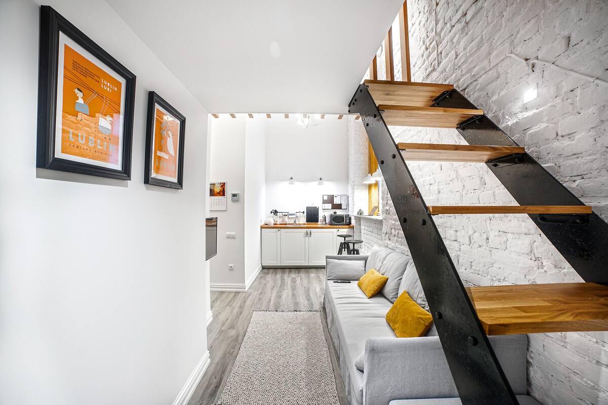 A modern interior with a staircase, a kitchen, and a living area.
