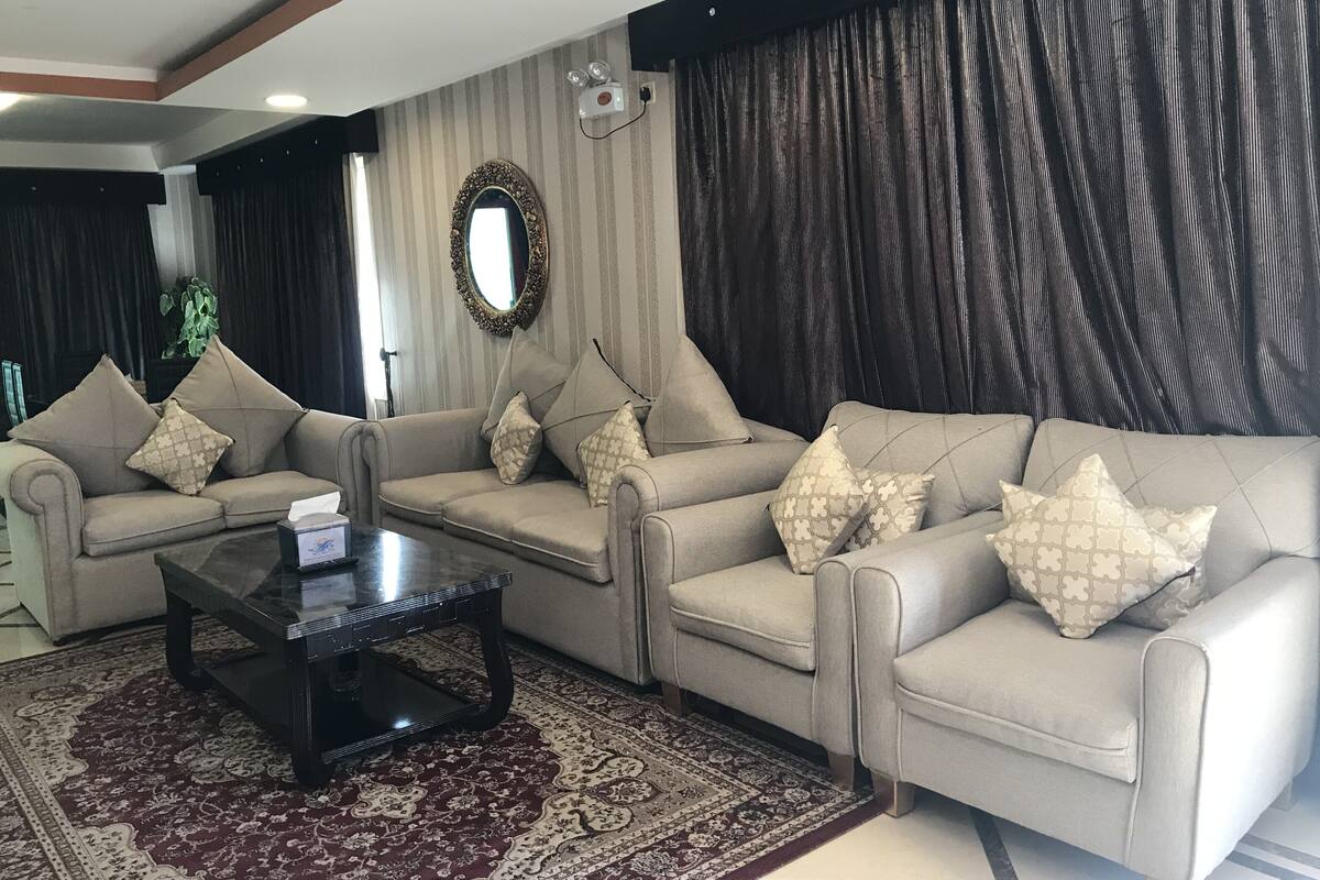 A living room with two sofas, a coffee table, and a patterned rug.